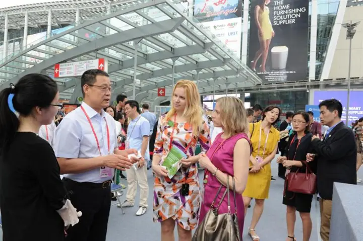 Compradores internacionais conversando com expositores durante a Canton Fair em Guangzhou